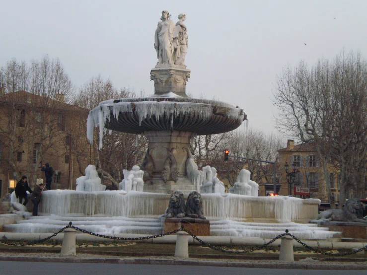 a large fountain has frozen water around it