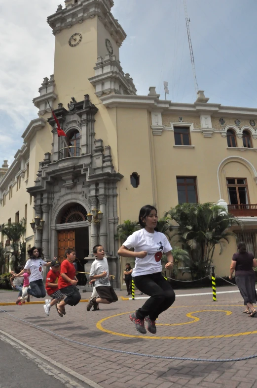 young children practice running outside an ornate building