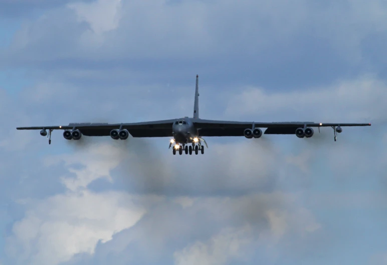 an airplane flying through the air under a cloudy sky