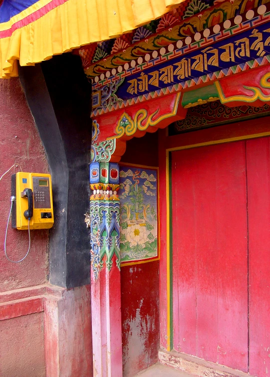 an oriental building with red doors and yellow walls