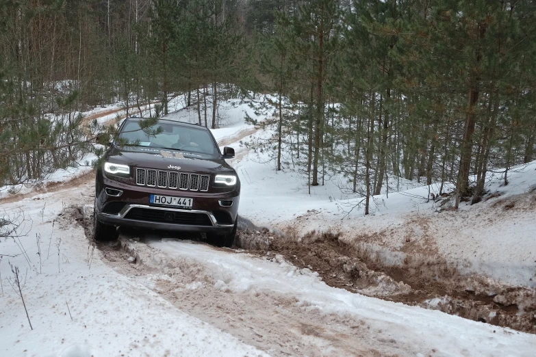 car coming up a snowy path in the woods