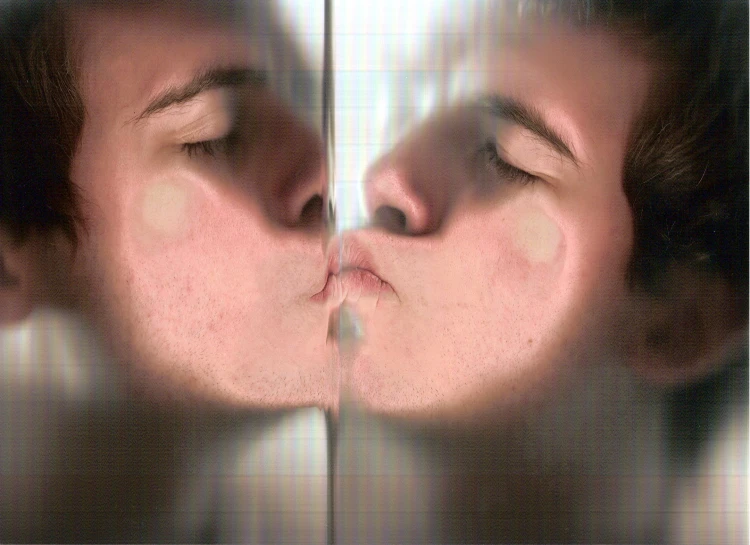 a couple kissing while the man is reflected in the mirror