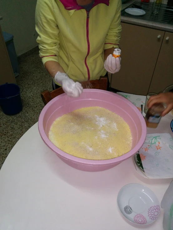 someone is using an item to make a mixture in a bowl