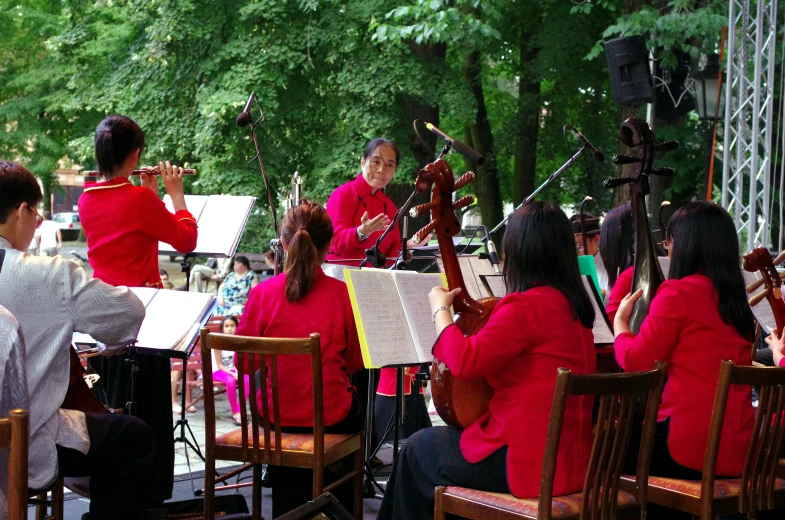 several women with red jackets playing instruments