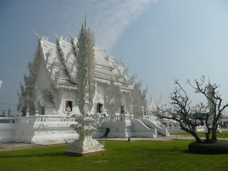 the trees are full of white flowers in front of the building