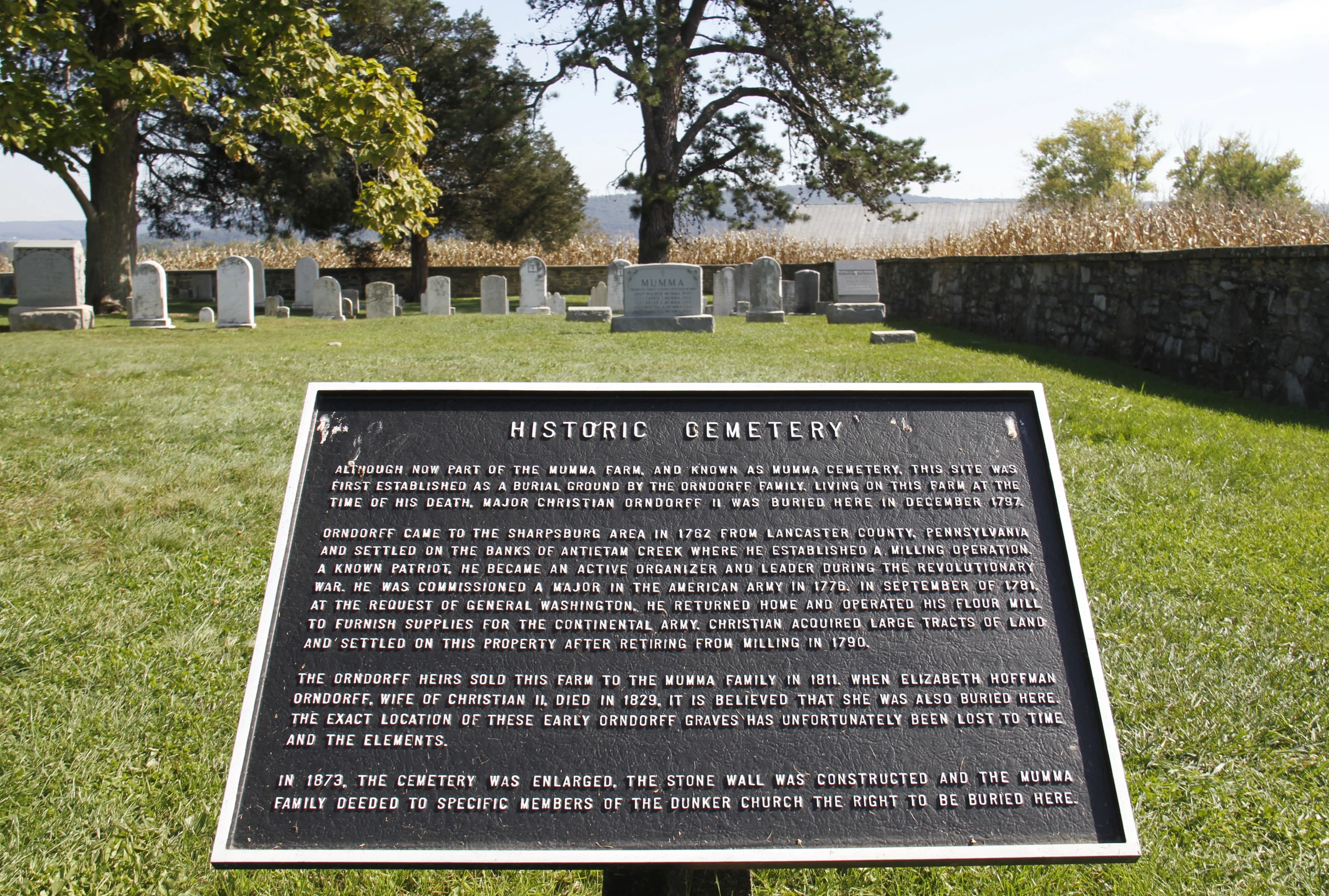 a memorial on a grassy hill surrounded by trees