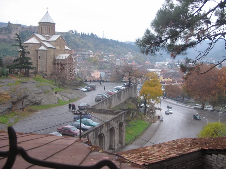 cars drive down a street next to the mountain