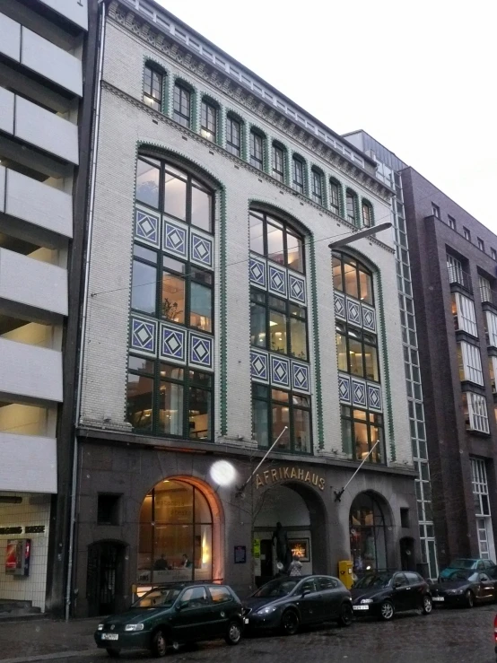 an old building with cars parked in front of it