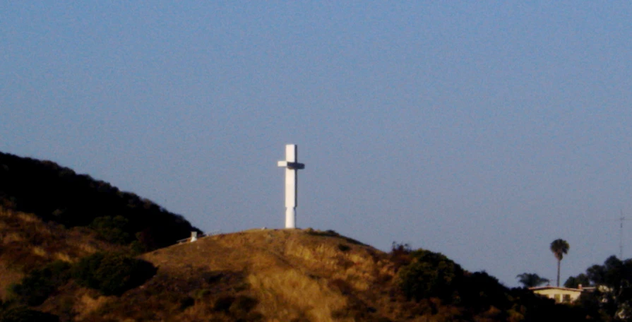 a white cross on a hillside at dusk