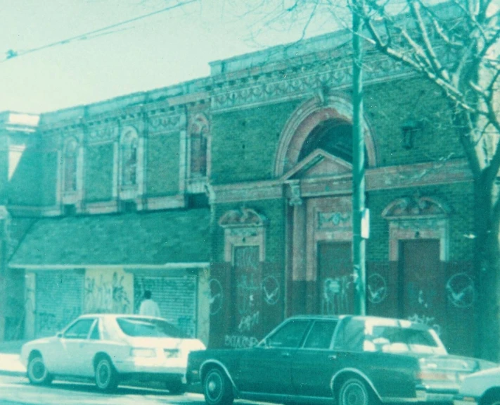 the building has many cars parked along the curb