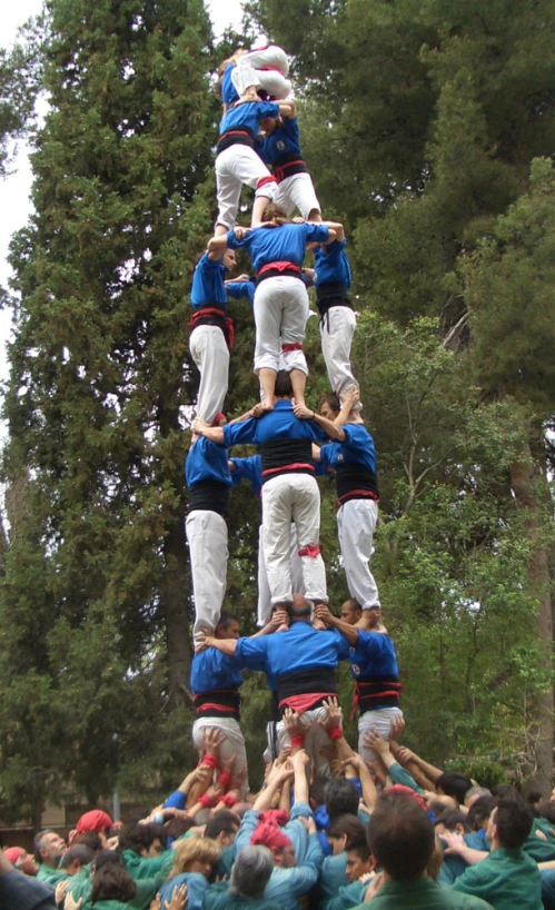 a group of men balancing on a large piece of wood