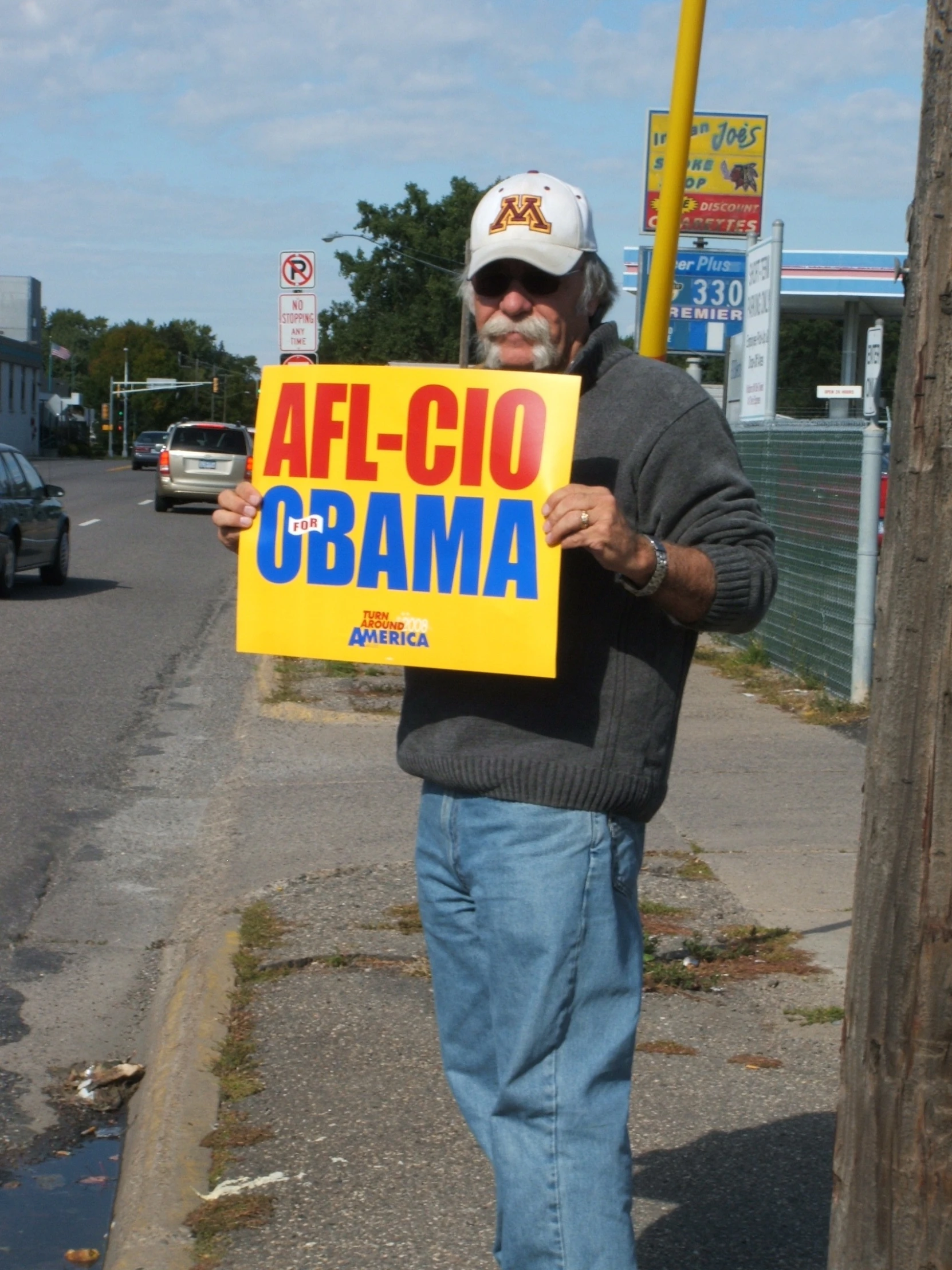 a man holding a sign in front of a street