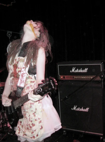 a woman playing a guitar at a band