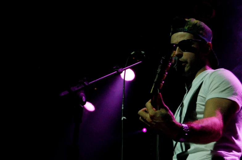 a man singing on a microphone next to a microphone with two lights