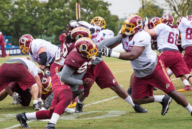 football players playing in a field with the opposing team