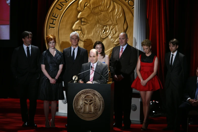 several people, all dressed up and posing for a po