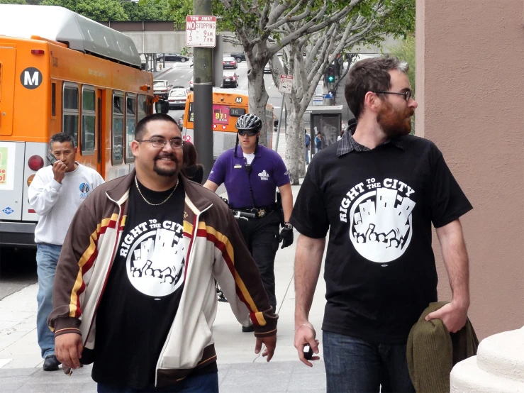 people on street next to a building and one person has glasses