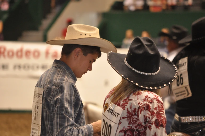 two men in cowboy hats, one with the word rodeo on his shirt