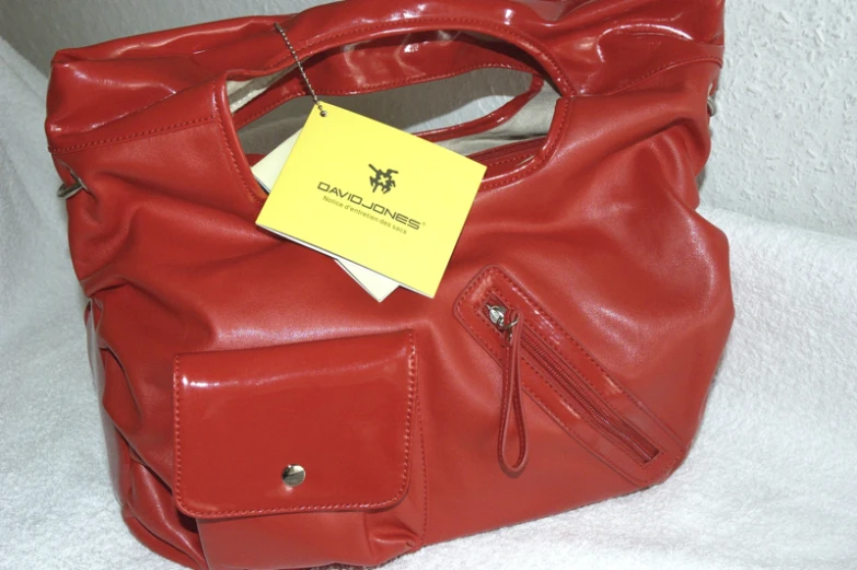 a red handbag that has a yellow sticker on it
