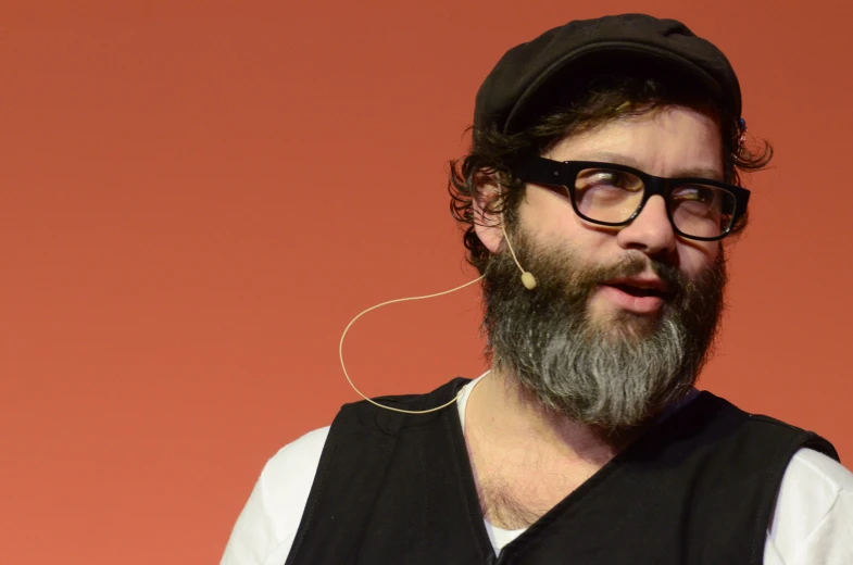 a man with glasses and beard wearing earbuds