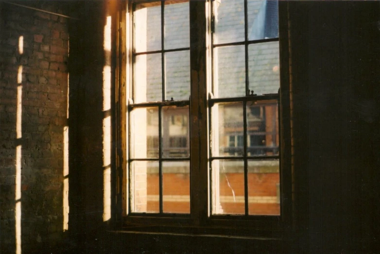 sunlight coming in from a window onto a red brick wall