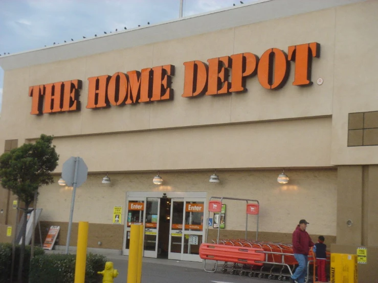 people are walking by the home depot store