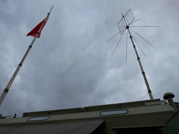 two masts on the top of a building, with a flag