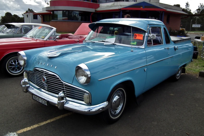 two vintage cars parked in front of a building