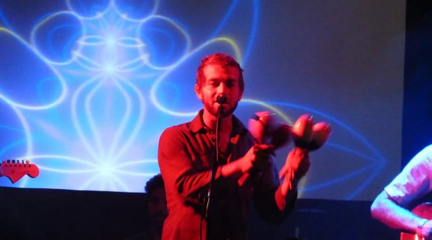 man holding up an object on stage with one hand