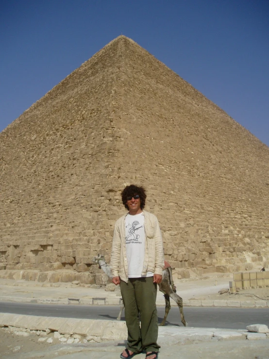 a young man standing in front of the great pyramid of giza