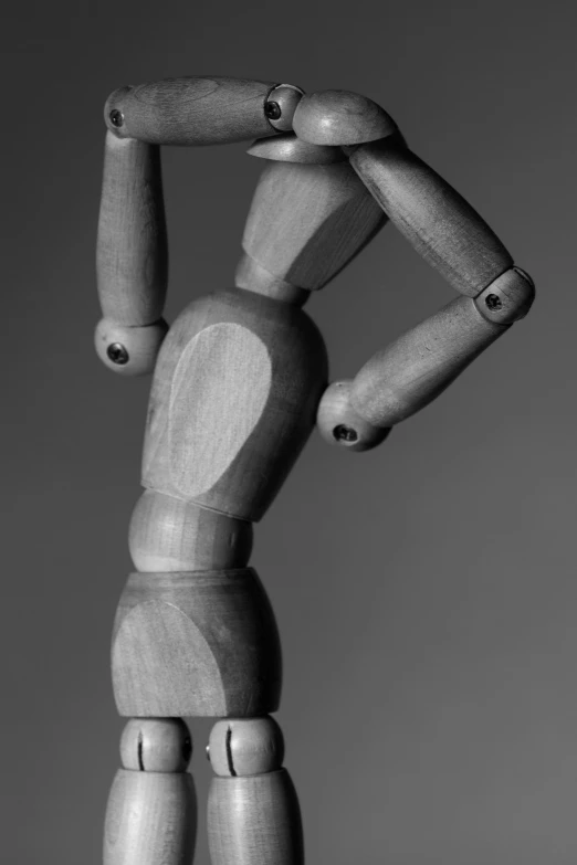 the wooden figure is posing for a black and white po