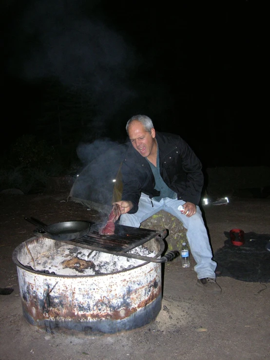 the man is preparing food by a big pot