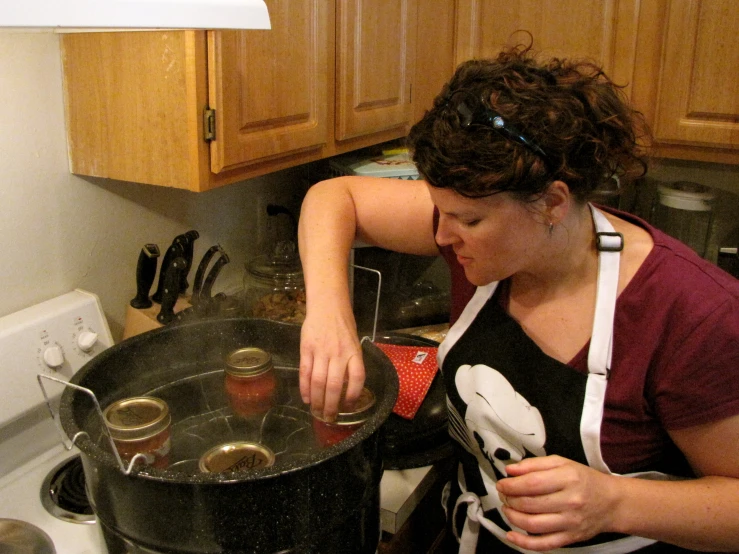 woman preparing food inside a kitchen on a stove