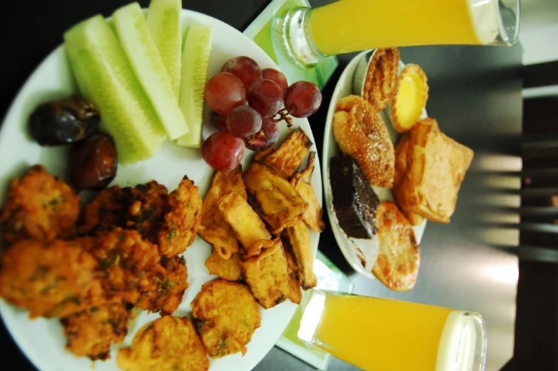 a plate full of fried food with a glass of juice