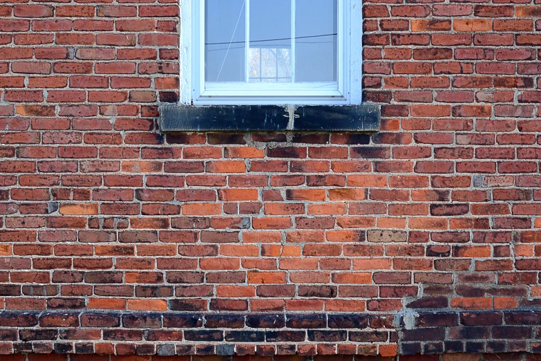 an old window on a brick building with white trim