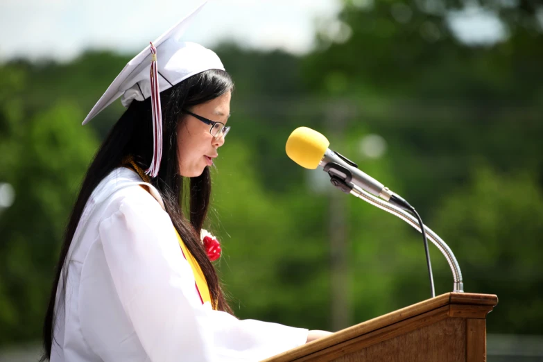 a woman in a cap and gown standing at a podium