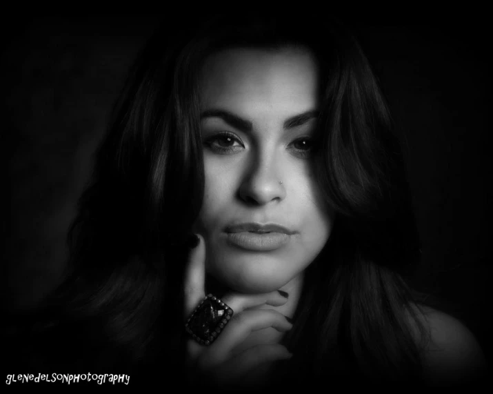 a woman poses with her hand under her chin