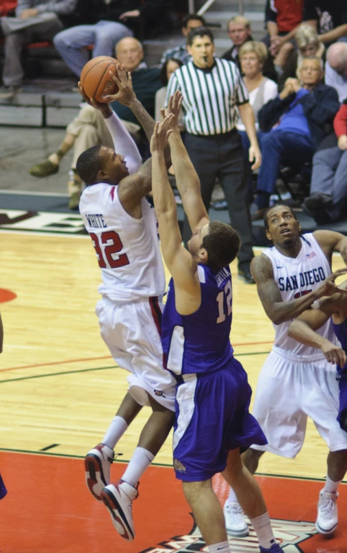 two men basketball players in blue and white are trying to score