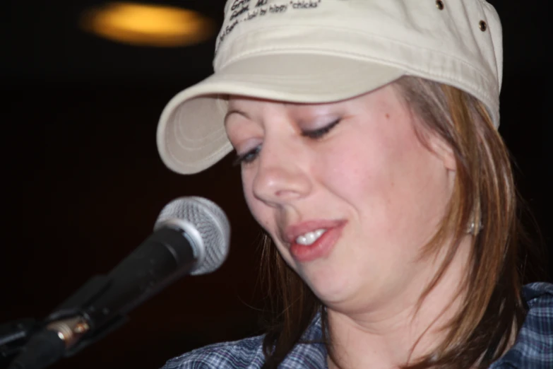 a young woman is singing into a microphone