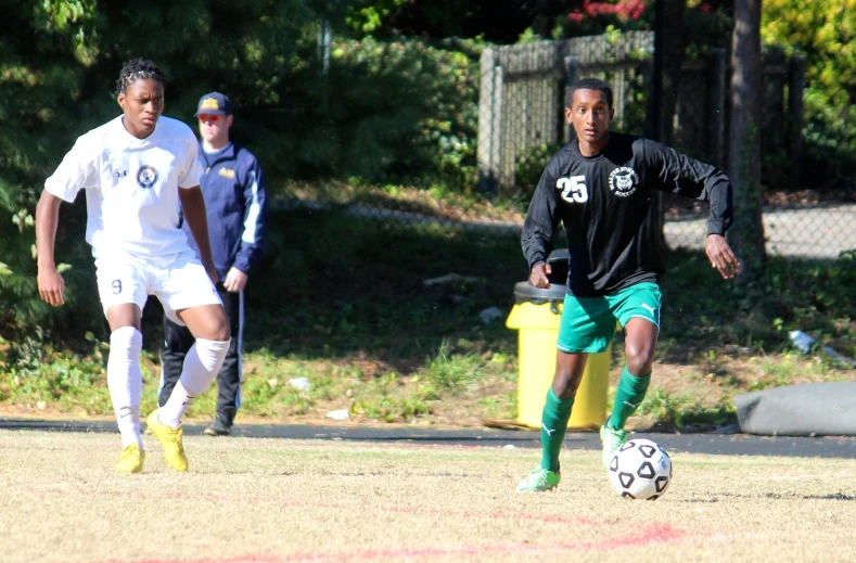 three boys are playing a soccer game