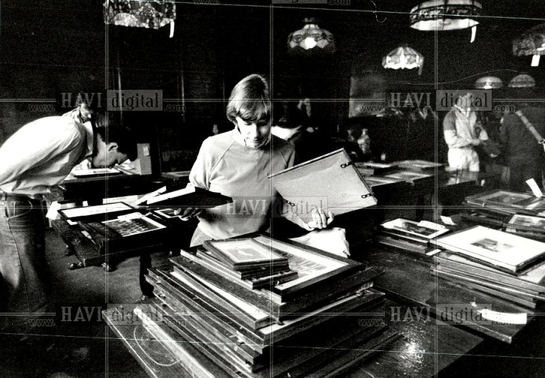 a woman at a desk with stacks of books