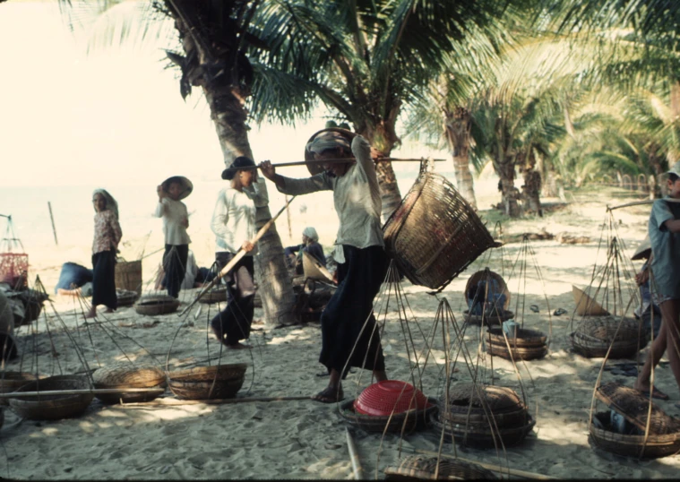 an old woman holding a basket and standing on the beach