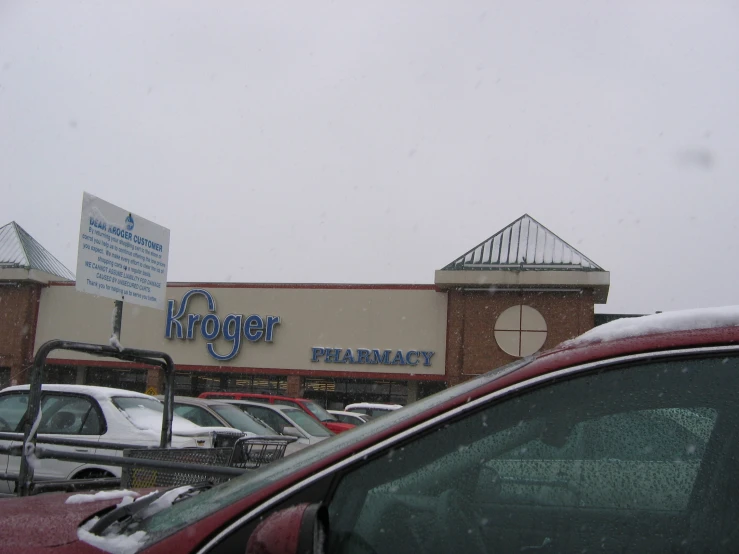 car dealership in a snowstorm with a building and cars