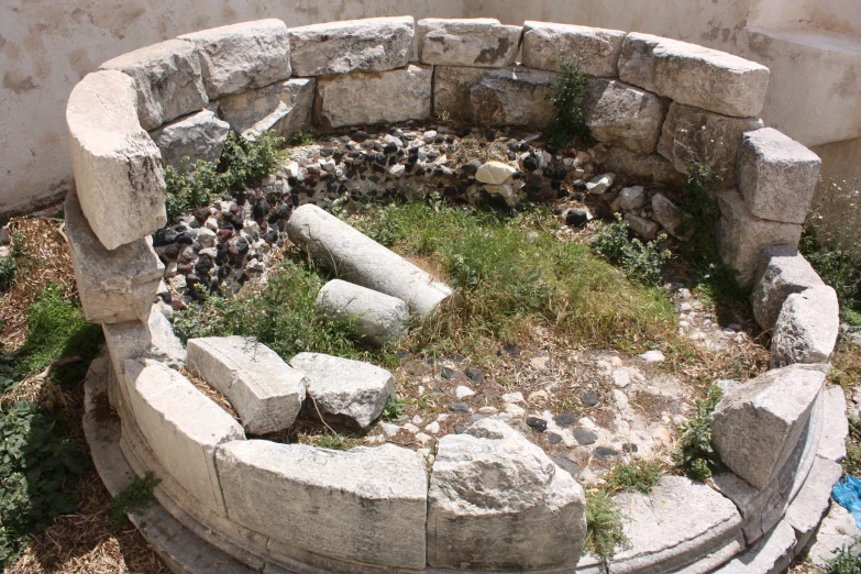 the stone firepit is made of rocks and grass