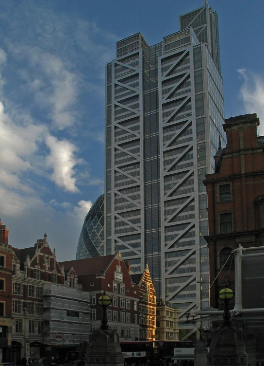 a tall building with many windows sitting next to some red brick buildings