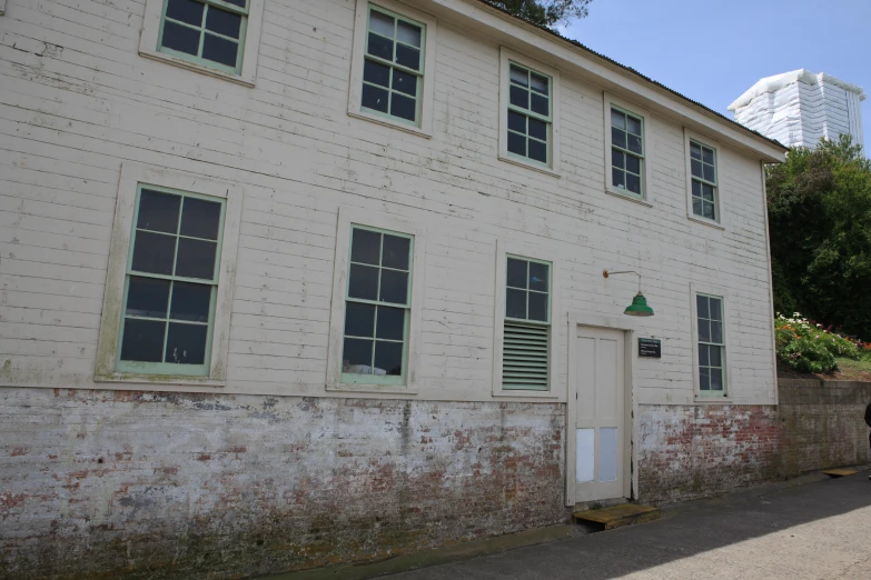 a white wall has two doors and is on a street side