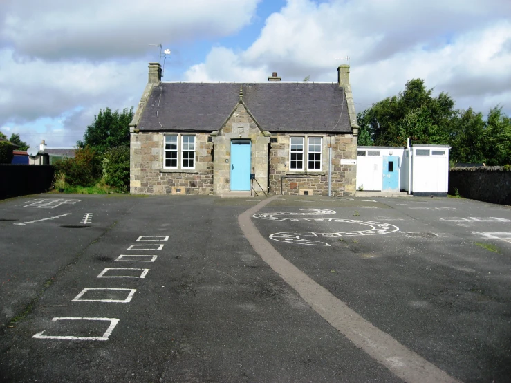 a stone house sits in the middle of an empty lot