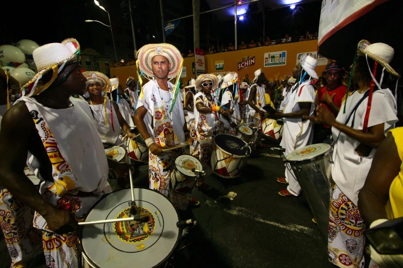 men and women in elaborate head dress playing drums