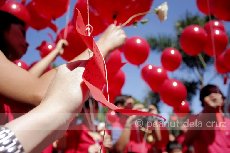 someone putting a red origami ball down to the sky