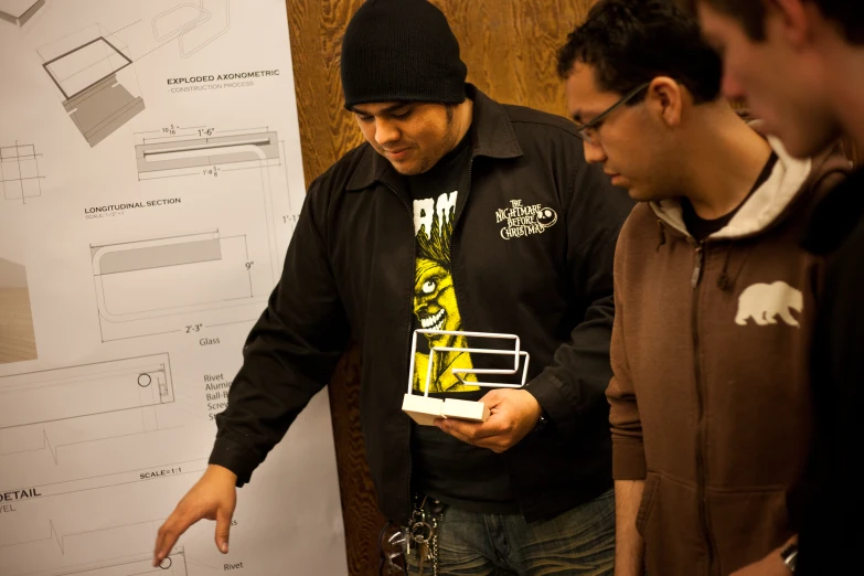 two men are standing next to a white board with drawings